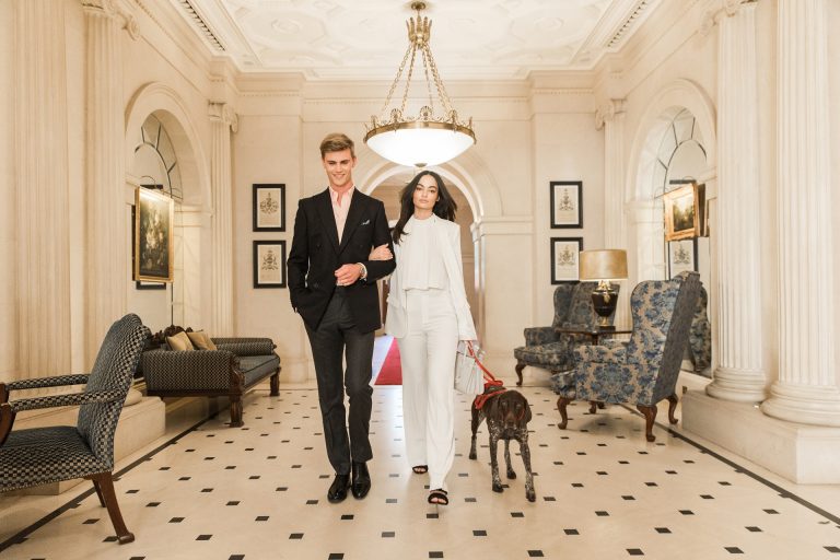 Picture of the hotel lobby with a woman and a man walking through it with their dog.