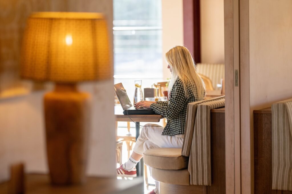 Woman working in lounge at Barnsgrove private members clubhouse